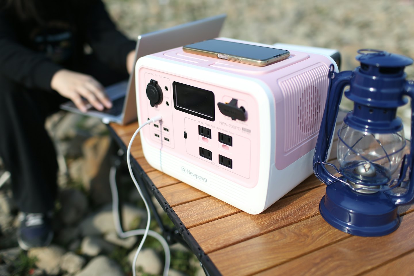 Tragbare Powerstation lädt Smartphone und Laptop im Freien.
