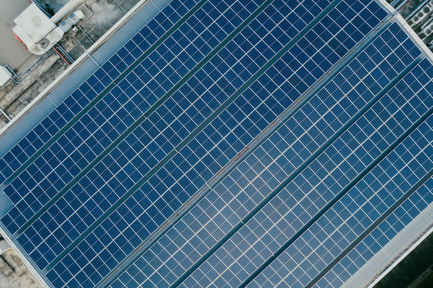 Blaue Solarmodule bedecken das Dach eines großen Geschäftsgebäudes.