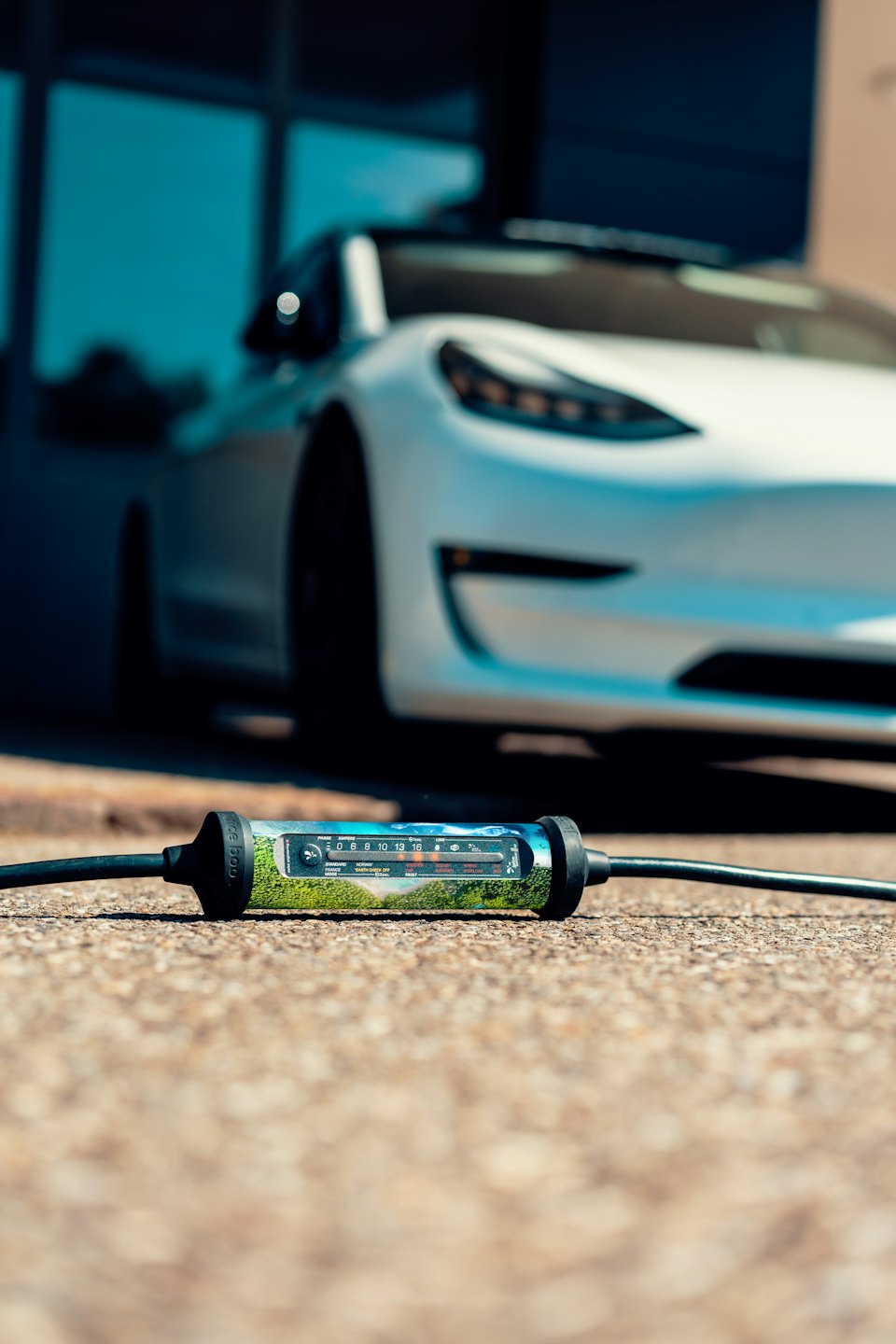 Ladekabel für Elektroautos mit digitaler Anzeige auf Betonboden.